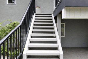 Freshly painted outdoor staircase with white steps and black railings on a modern home